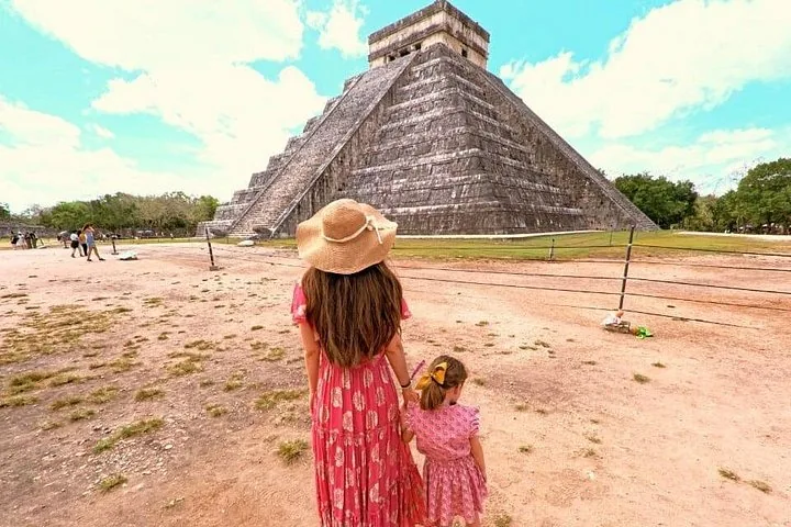Una donna e un bambino osservano in piedi la piramide di El Castillo.
